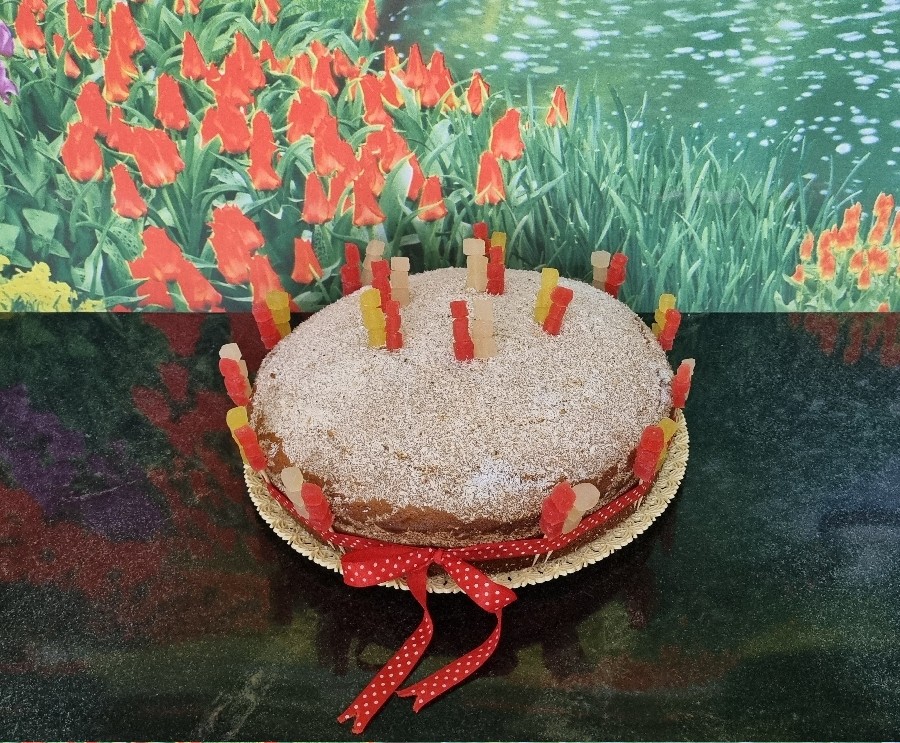 کیک ساده با تزیین پودرنارگیل و حبه میوهِ استوایی